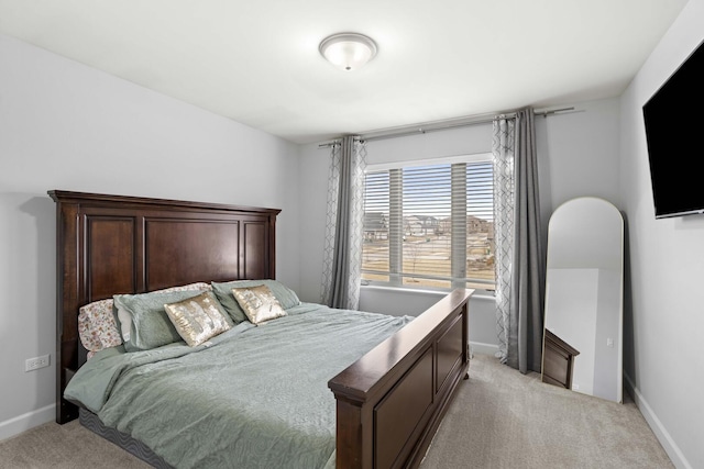 bedroom featuring light carpet and baseboards