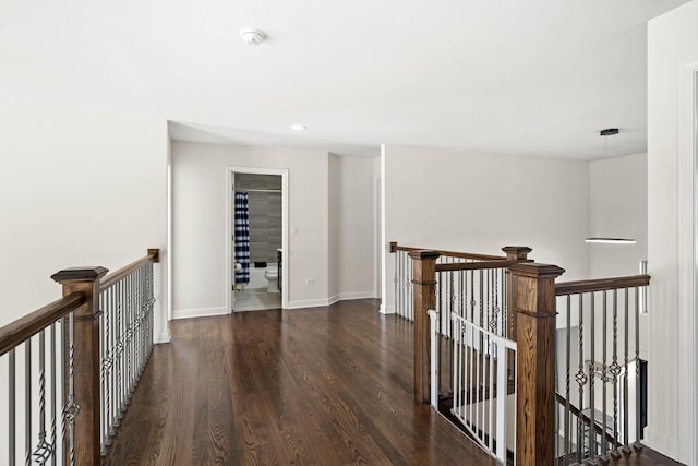 hallway with dark wood-type flooring, recessed lighting, an upstairs landing, and baseboards