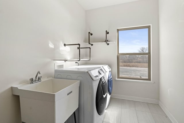 laundry room featuring washer and dryer, laundry area, a sink, and baseboards