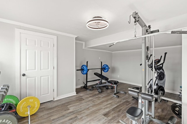 exercise area featuring crown molding, baseboards, and wood finished floors