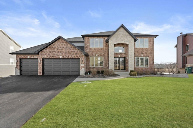 view of front of property featuring driveway, brick siding, an attached garage, and a front yard