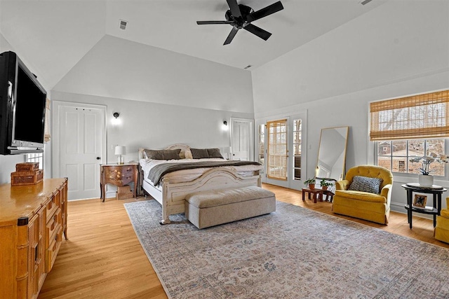 bedroom featuring light wood-style floors, visible vents, high vaulted ceiling, and a ceiling fan