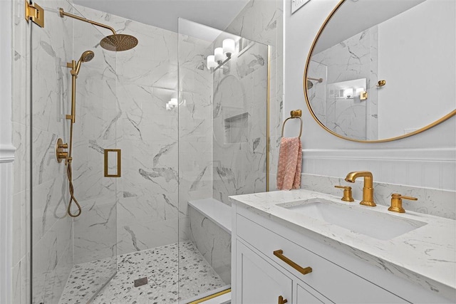 full bathroom with a marble finish shower and vanity