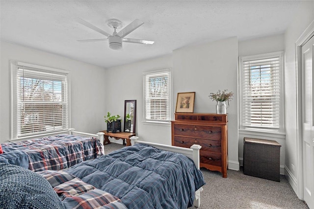 carpeted bedroom featuring a textured ceiling and multiple windows