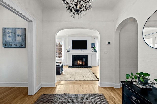 corridor with baseboards and wood finished floors