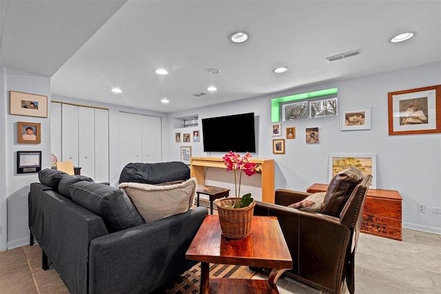 living area featuring baseboards, visible vents, and recessed lighting