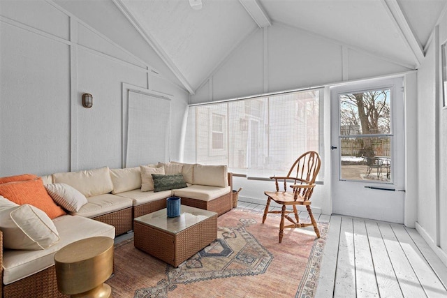 sunroom featuring lofted ceiling with beams