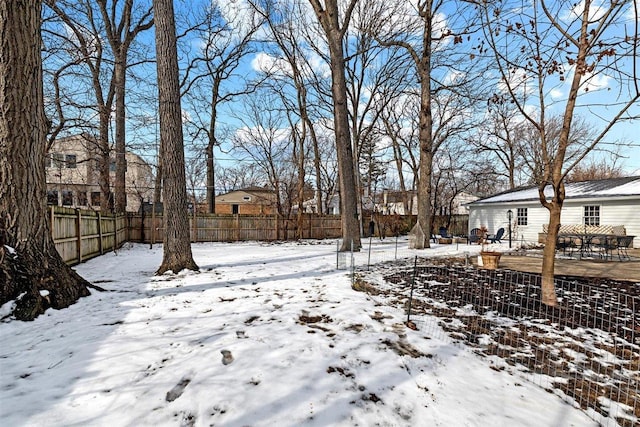 snowy yard featuring fence