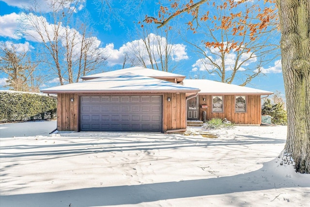 view of front of house featuring board and batten siding, driveway, and an attached garage