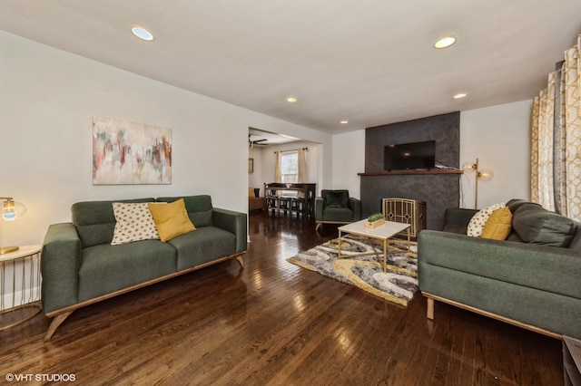 living room with hardwood / wood-style floors, recessed lighting, and a large fireplace