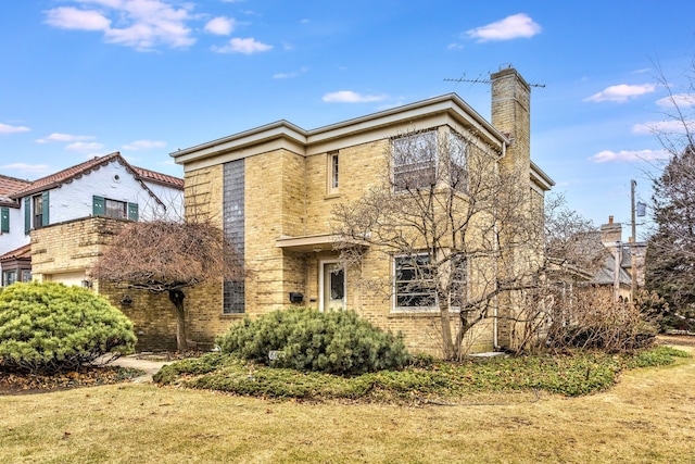 view of front of property featuring a front yard, brick siding, and a chimney