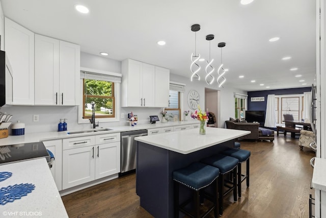 kitchen featuring appliances with stainless steel finishes, light countertops, white cabinets, and a sink