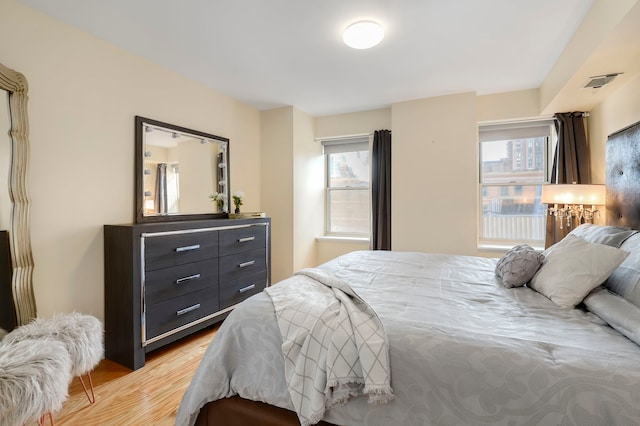 bedroom with light wood-style flooring and visible vents