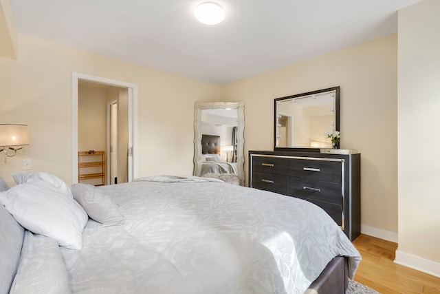 bedroom with light wood-style flooring and baseboards