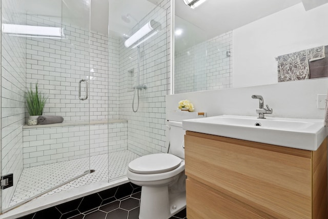 bathroom featuring tile patterned flooring, a shower stall, vanity, and toilet