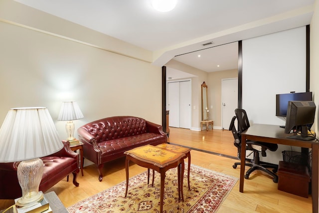 office with light wood finished floors, visible vents, and baseboards