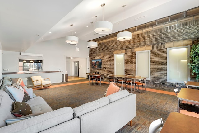 living area with brick wall, high vaulted ceiling, dark colored carpet, and recessed lighting