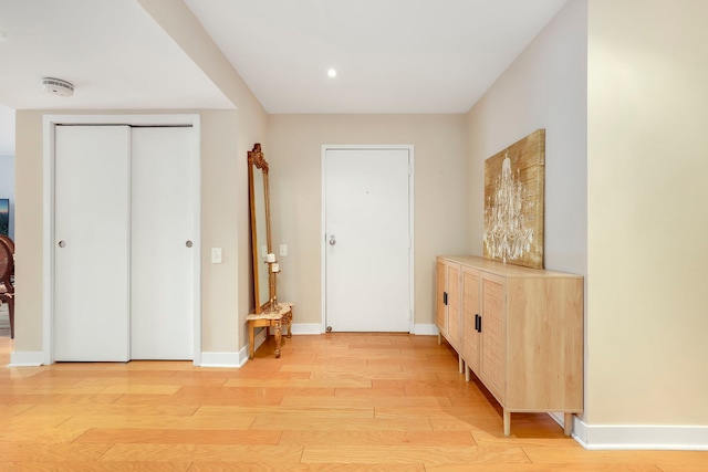 foyer with light wood-type flooring and baseboards