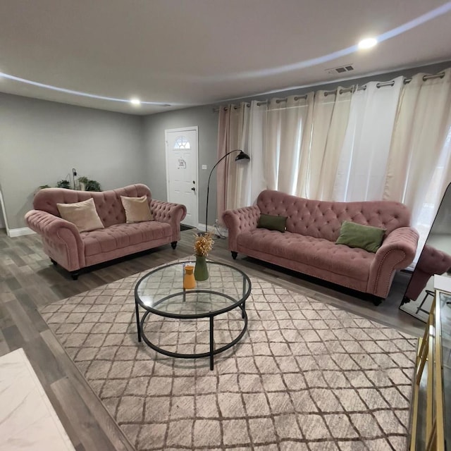 living area with recessed lighting, visible vents, baseboards, and wood finished floors