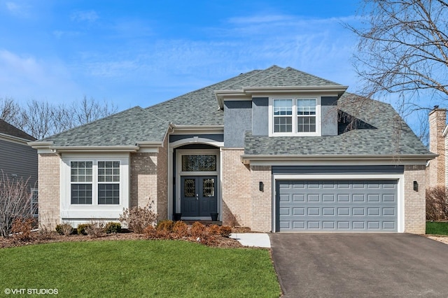 view of front of house featuring aphalt driveway, a shingled roof, a front lawn, and brick siding