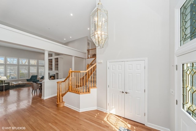 foyer featuring a chandelier, stairway, a wealth of natural light, and wood finished floors