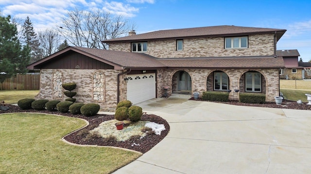 view of front of property with brick siding, concrete driveway, an attached garage, a front yard, and fence