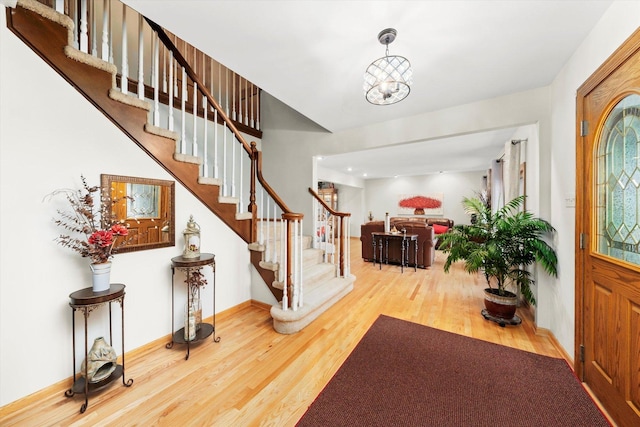 entrance foyer with stairway, baseboards, and wood finished floors