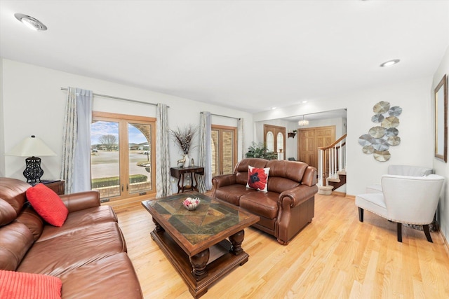 living room featuring stairway and light wood finished floors