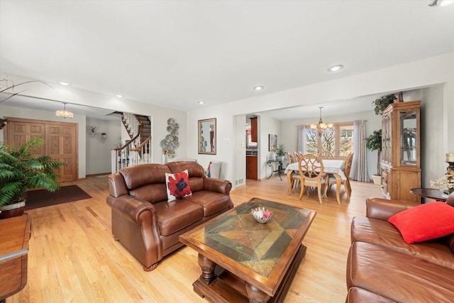 living area with light wood-style flooring, stairway, a chandelier, and recessed lighting