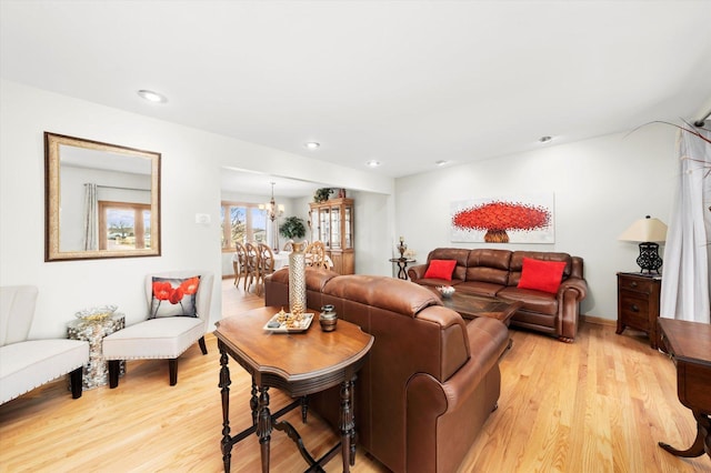 living room featuring recessed lighting, light wood-type flooring, and an inviting chandelier