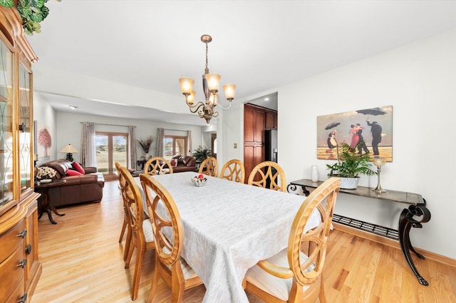 dining room with a notable chandelier and light wood-style flooring