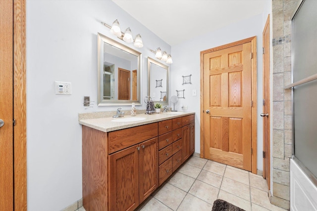 bathroom with double vanity, an enclosed shower, a sink, and tile patterned floors