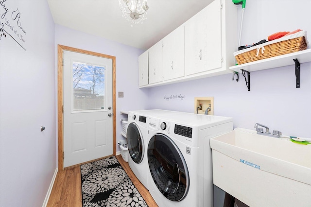 laundry room with washer and clothes dryer, cabinet space, light wood-style floors, a sink, and baseboards