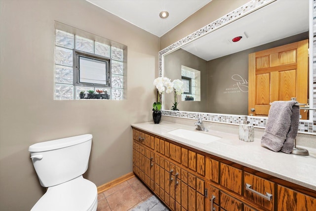 bathroom with toilet, tile patterned flooring, baseboards, and vanity