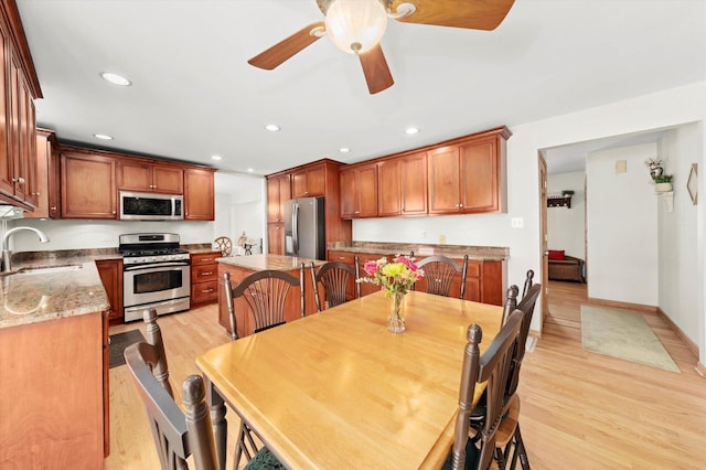 dining space featuring baseboards, light wood-type flooring, a ceiling fan, and recessed lighting