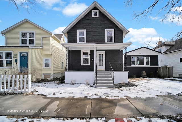 american foursquare style home featuring covered porch and stone siding