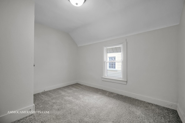 additional living space with carpet, vaulted ceiling, and baseboards