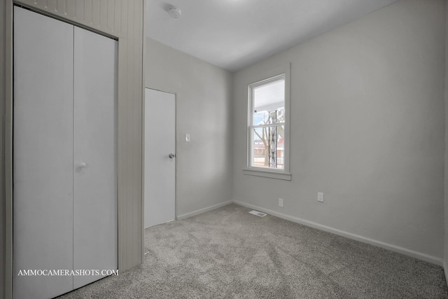 unfurnished bedroom with light carpet, a closet, and baseboards