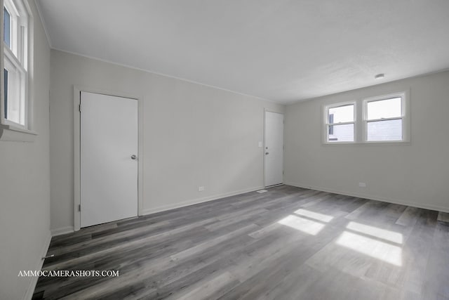 spare room featuring baseboards and wood finished floors