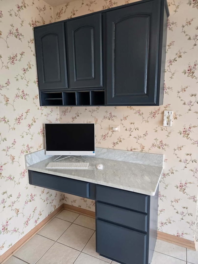 interior space featuring light countertops, light tile patterned flooring, and wallpapered walls