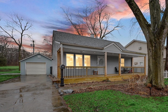 view of front of house featuring an outbuilding, roof with shingles, a detached garage, covered porch, and driveway