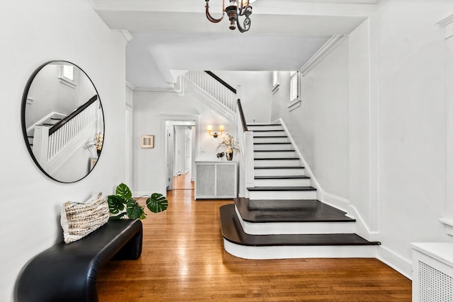 714 Sheridan Rd, Evanston, IL 60202 - stairway with wood finished floors, a chandelier, crown molding, and baseboards
