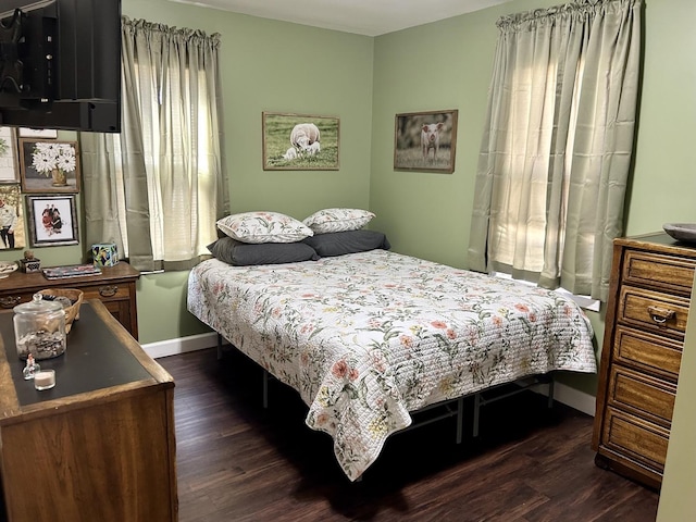 bedroom with dark wood finished floors and baseboards