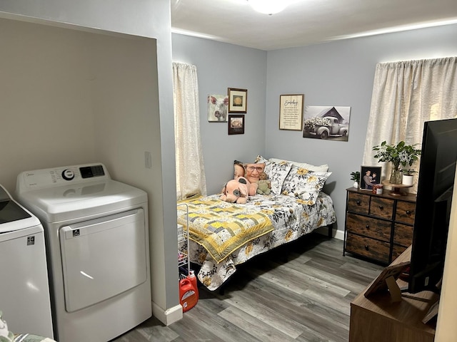 bedroom with baseboards, wood finished floors, and washing machine and clothes dryer