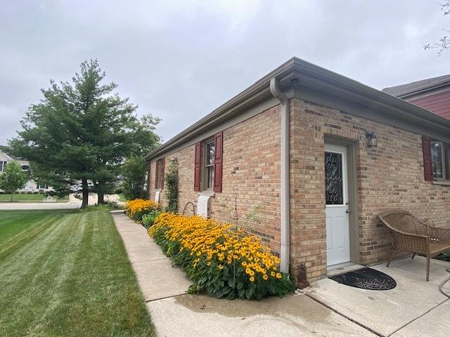view of side of property with brick siding and a yard