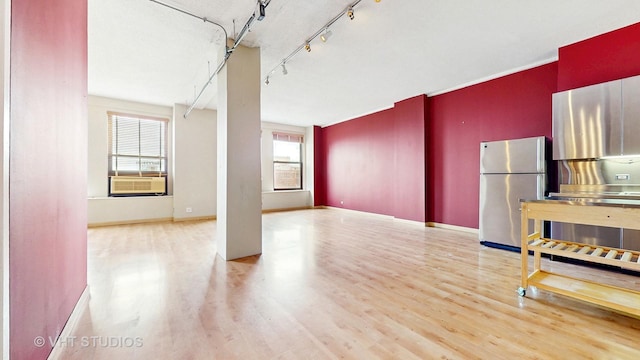 unfurnished living room featuring baseboards, wood finished floors, and cooling unit