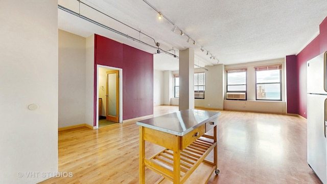 kitchen with freestanding refrigerator, baseboards, a wealth of natural light, and cooling unit