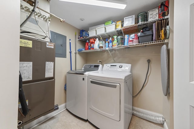 laundry room with laundry area, electric panel, washer and clothes dryer, and baseboards