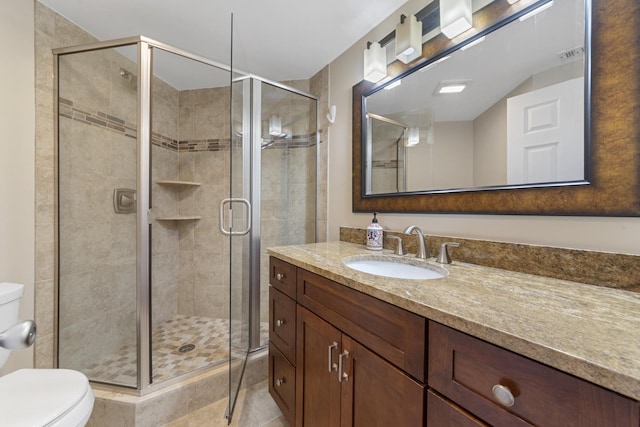 bathroom with toilet, a shower stall, visible vents, and vanity