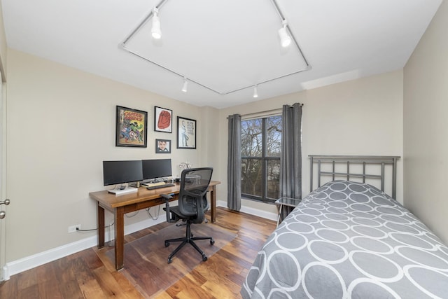 bedroom featuring attic access, baseboards, and wood finished floors